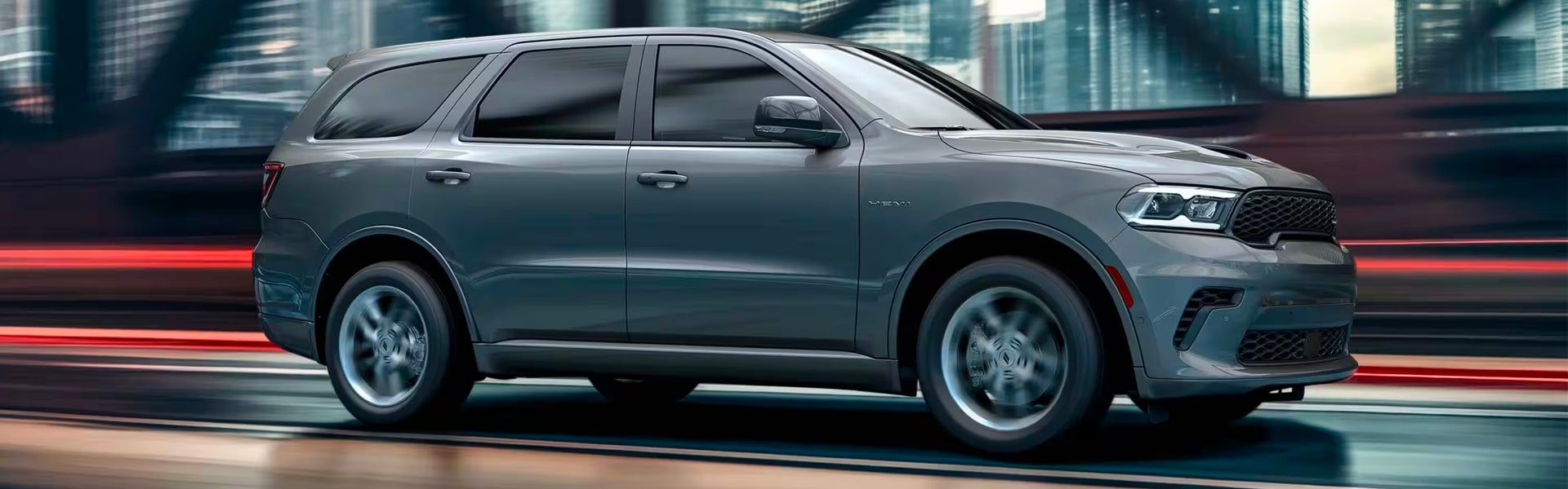 A silver suv driving on the road.