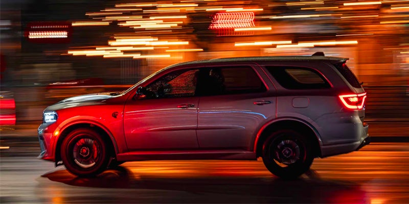 A silver suv driving on the road.