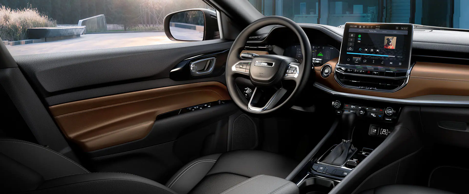 the interior technology of a jeep compass suv showcasing the steering wheel and infotainment display