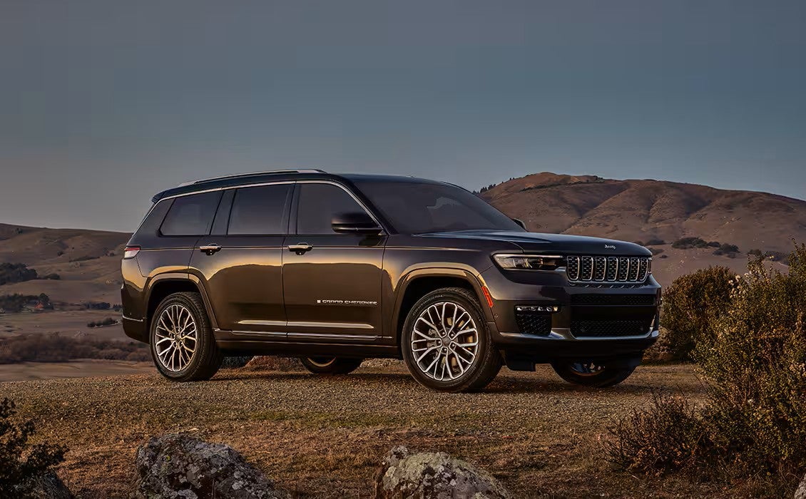 a 2025 jeep grand cherokee parked on a desert terrain at sunset