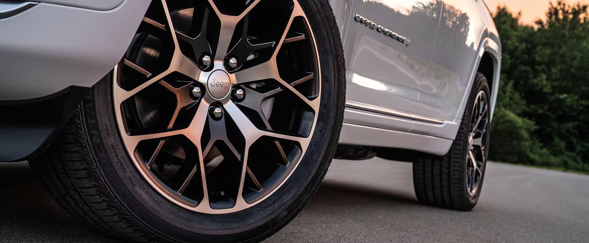 a close up of the front drivers wheel on a white 2025 jeep grand cherokee