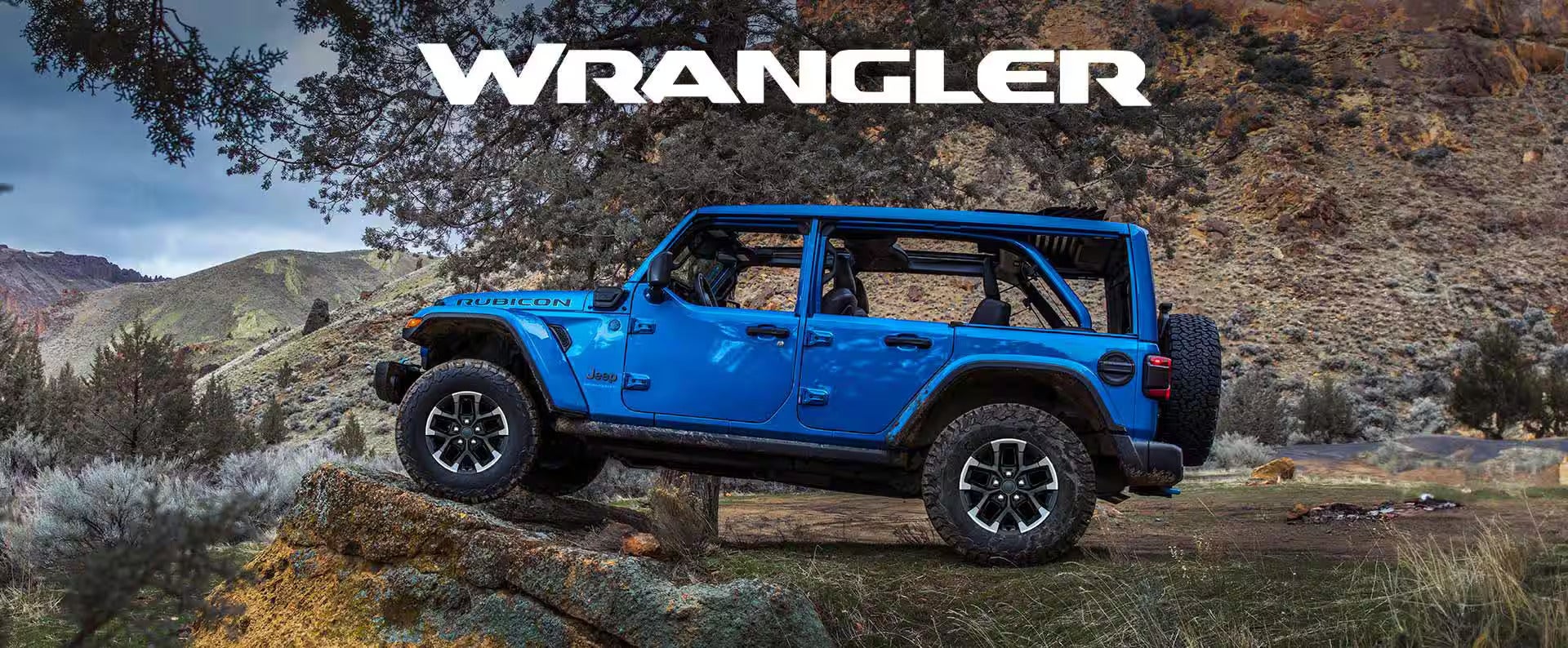 a blue jeep wrangler in the wilderness with the Wrangler heading above the jeep.