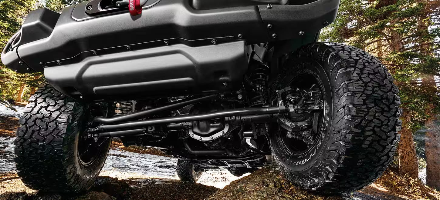 the front undercarrage of a jeep wrangler going over rocks and water
