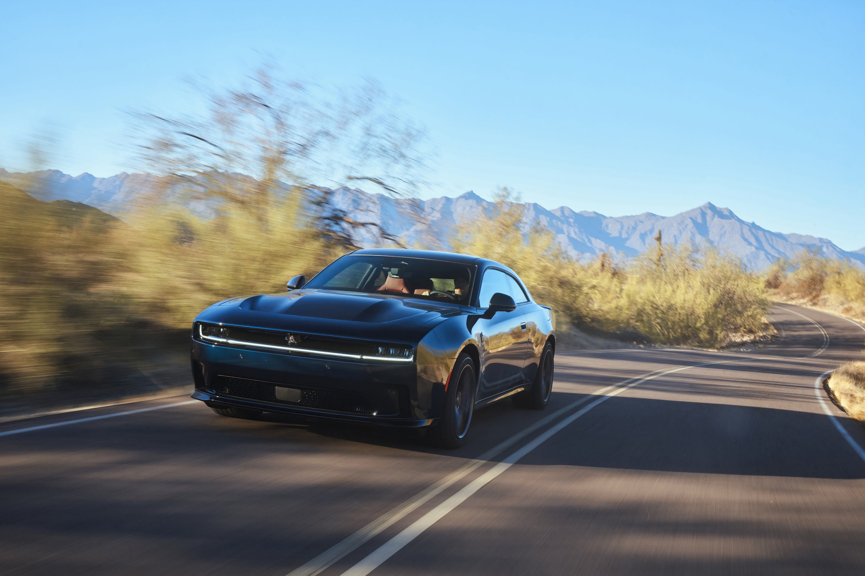 A green charger driving through the snow.