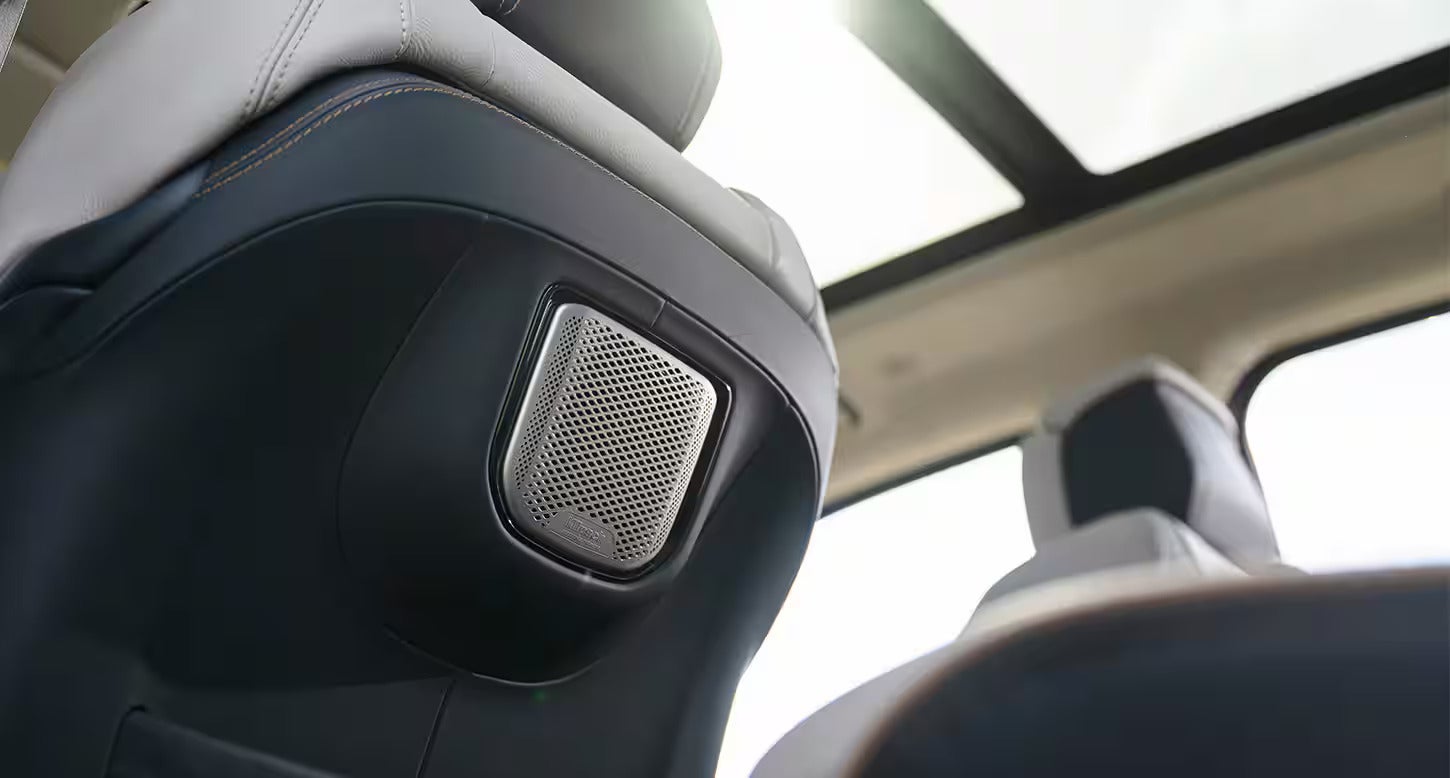 Speaker embedded in the back of the front seat of the 2025 Ram 1500 REV, showcasing the vehicle's audio system and interior design.