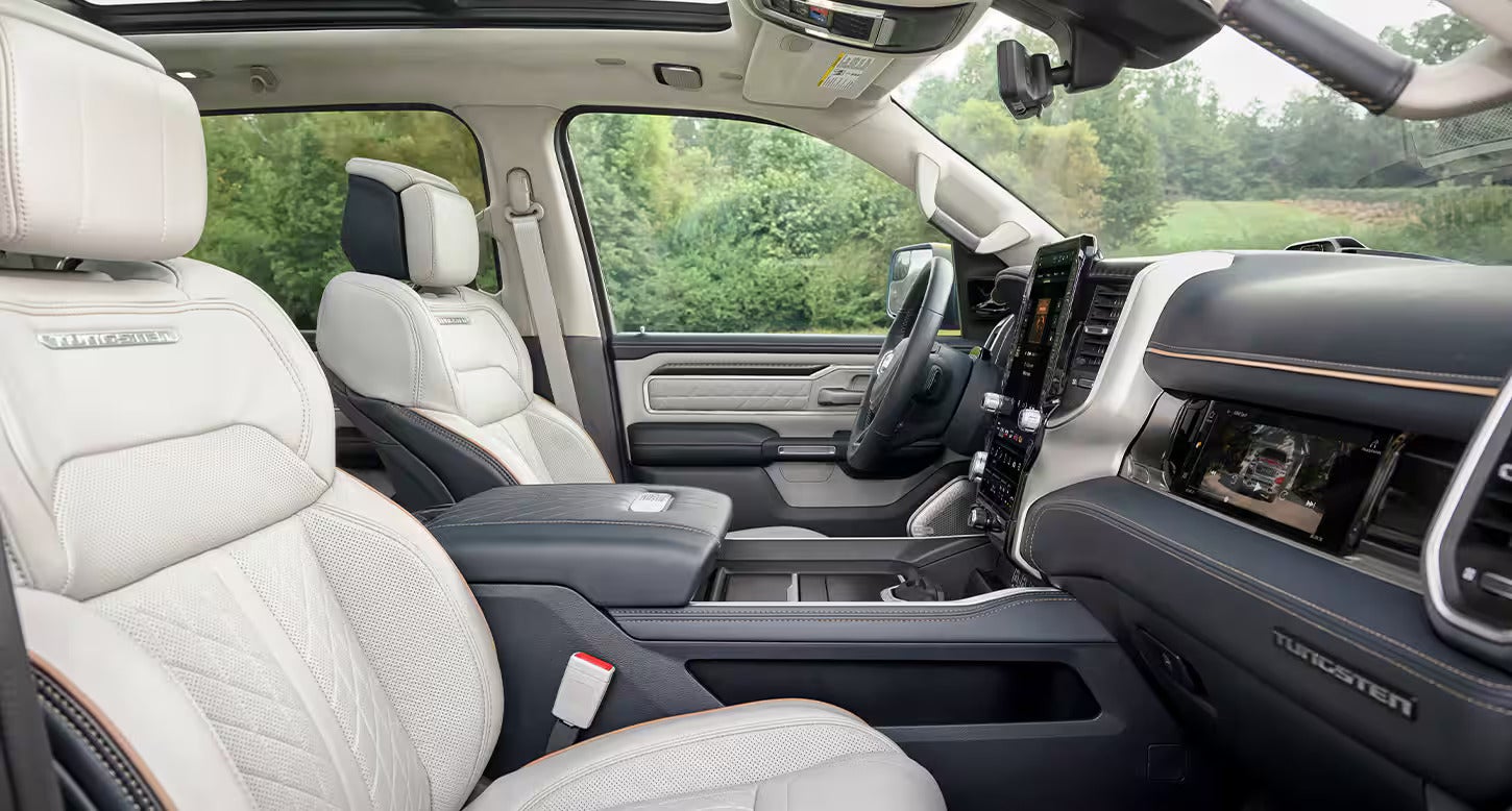 Luxurious interior view of the 2025 Ram 1500 REV with leather seats and a panoramic sunroof, emphasizing comfort and space.
