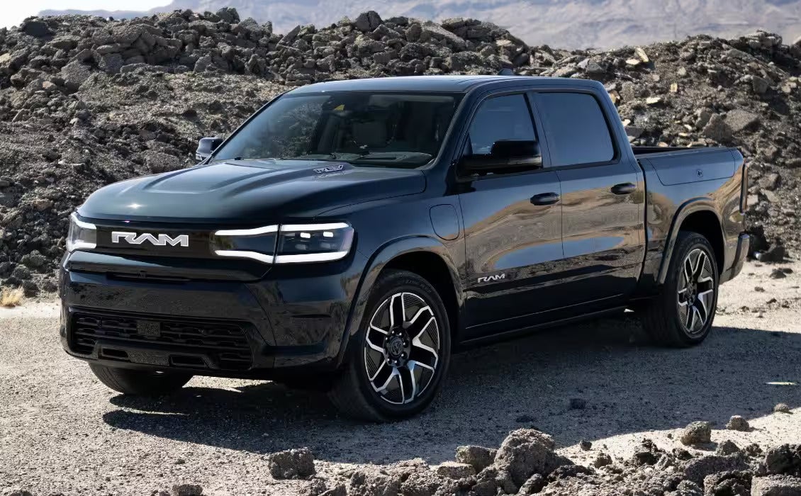 2025 Ram 1500 REV truck parked in a mountainous terrain, showcasing its bold and rugged exterior design.