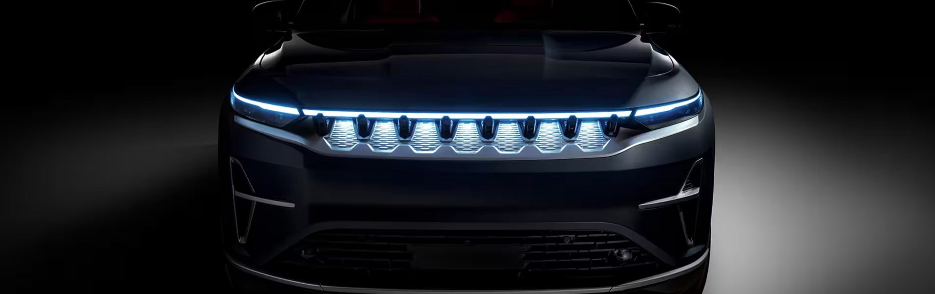 The front end of the 2024 Jeep Wagoneer S lit up in the dark.